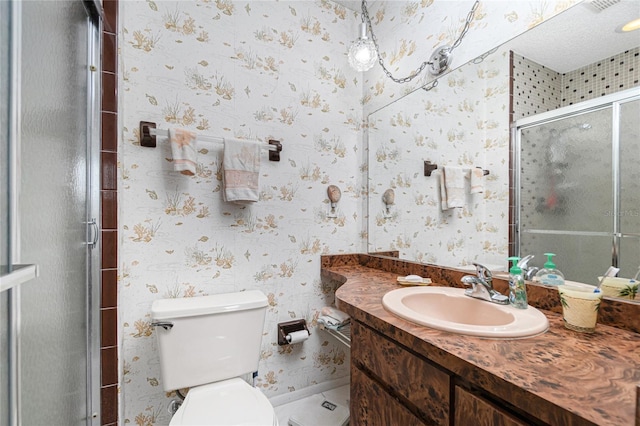 bathroom featuring vanity, a shower with shower door, and toilet