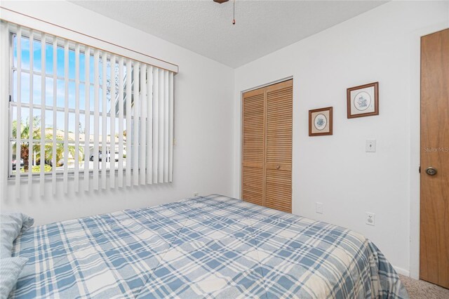 bedroom with a closet, carpet, and a textured ceiling