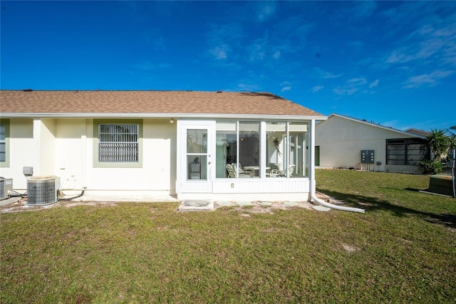 rear view of property featuring a yard, central AC unit, and a sunroom