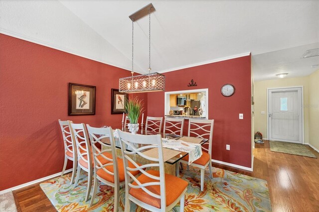 dining space featuring hardwood / wood-style floors and vaulted ceiling