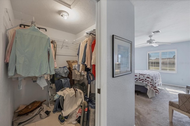 walk in closet featuring ceiling fan and carpet