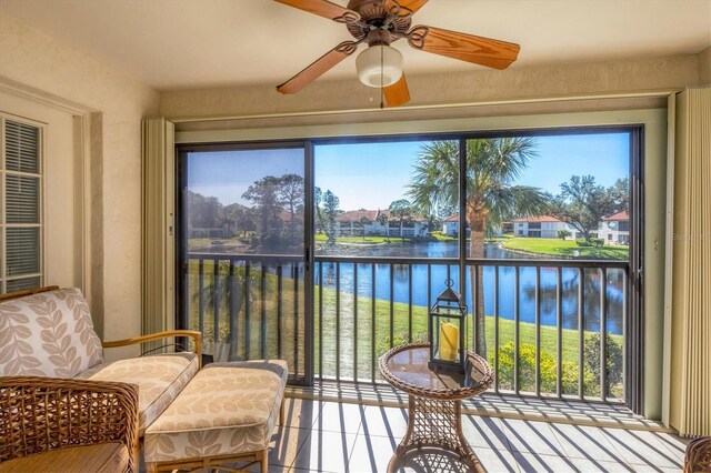 sunroom / solarium with ceiling fan, a water view, and a healthy amount of sunlight