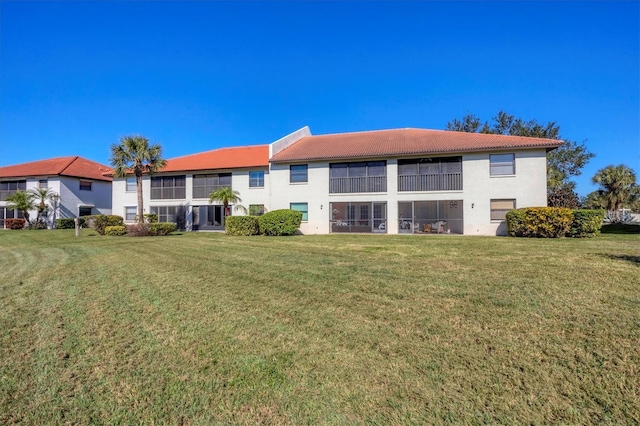 rear view of property featuring a lawn