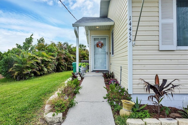 doorway to property with a lawn