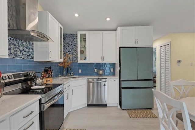 kitchen featuring white cabinetry, sink, wall chimney range hood, and stainless steel appliances