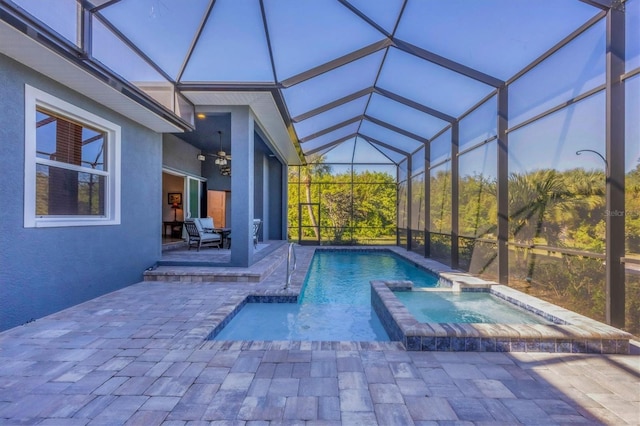 view of pool with a lanai, a patio area, and an in ground hot tub