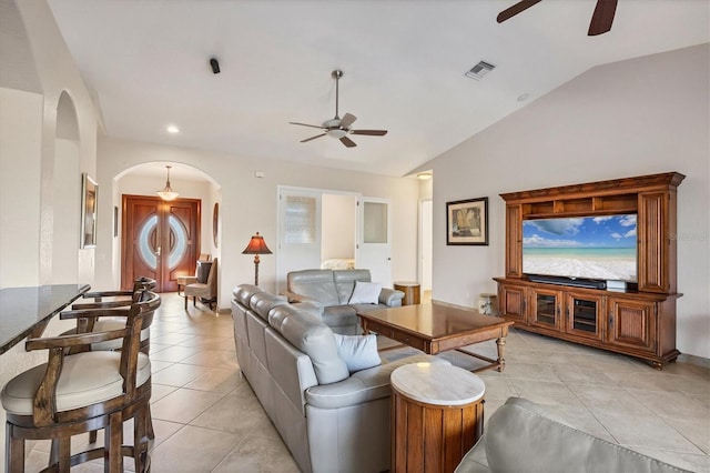 living room with a wealth of natural light, ceiling fan, lofted ceiling, and light tile patterned floors