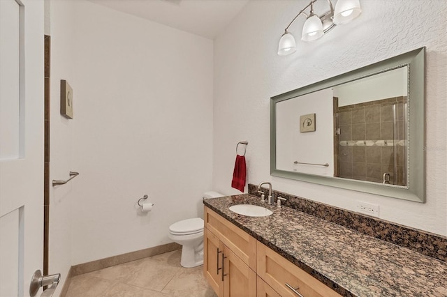 bathroom with toilet, vanity, tile patterned floors, and walk in shower