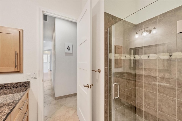 bathroom featuring tile patterned flooring, vanity, and walk in shower