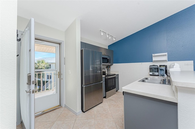 kitchen featuring rail lighting, light tile patterned floors, sink, and appliances with stainless steel finishes