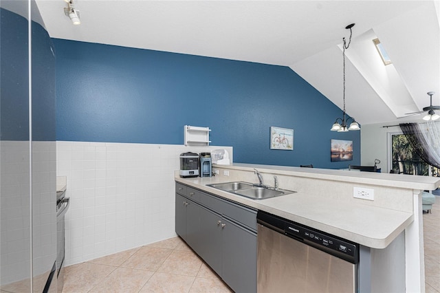 kitchen with stainless steel dishwasher, gray cabinetry, sink, light tile patterned floors, and decorative light fixtures