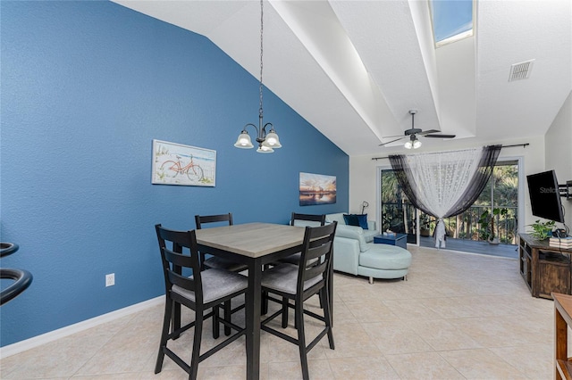 tiled dining space with ceiling fan with notable chandelier and lofted ceiling