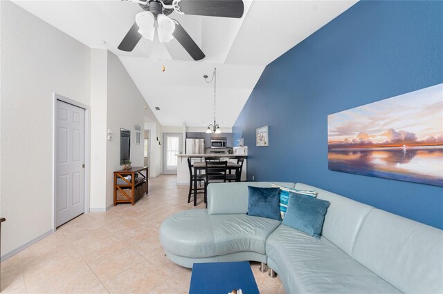 tiled living room with high vaulted ceiling and ceiling fan with notable chandelier