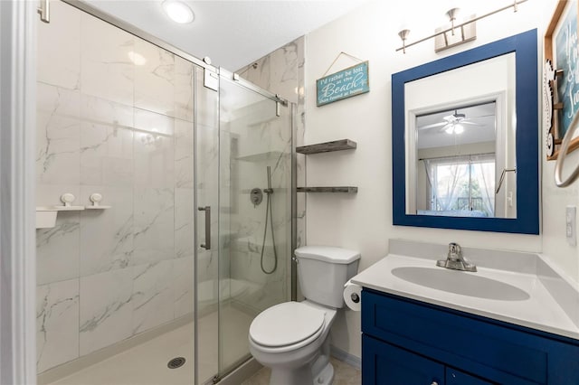 bathroom featuring ceiling fan, toilet, a shower with door, and vanity