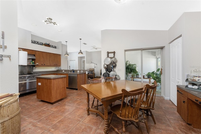 kitchen with vaulted ceiling, appliances with stainless steel finishes, decorative light fixtures, a kitchen island, and kitchen peninsula