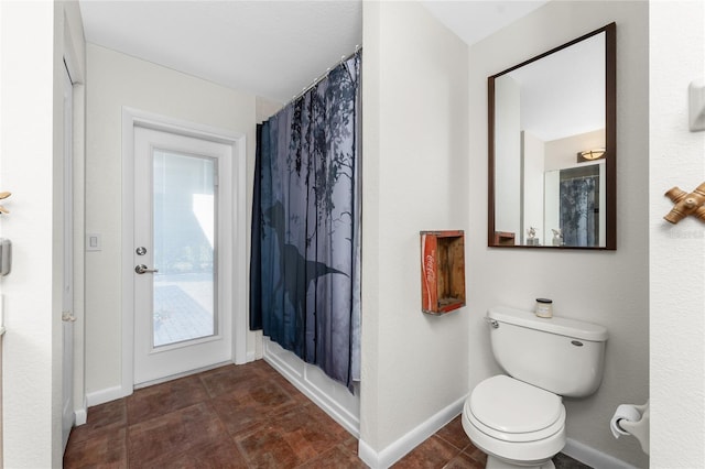 bathroom with a shower with shower curtain and toilet