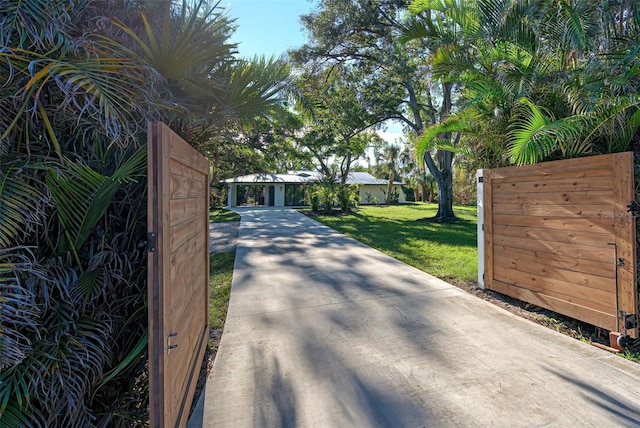 view of gate with a lawn