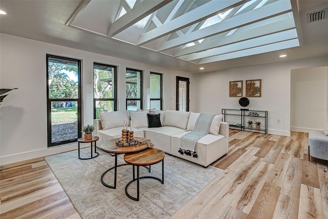 living room with light hardwood / wood-style floors and high vaulted ceiling