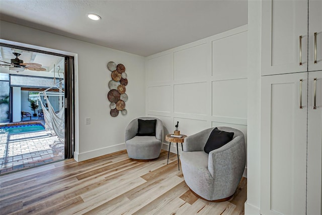 living area with light wood-type flooring and ceiling fan