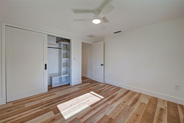 unfurnished bedroom featuring a closet, light hardwood / wood-style floors, and ceiling fan