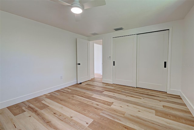 unfurnished bedroom featuring ceiling fan, a closet, and light wood-type flooring