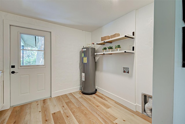 clothes washing area featuring hookup for a washing machine, light wood-type flooring, and water heater