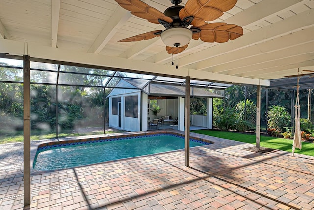 view of swimming pool featuring glass enclosure, ceiling fan, and a patio area