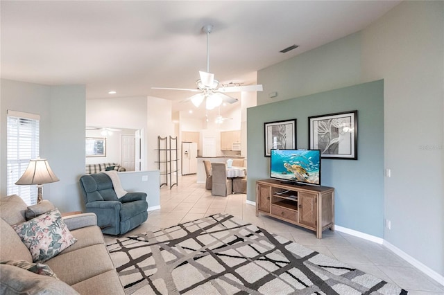 living room with lofted ceiling, ceiling fan, and light tile patterned floors