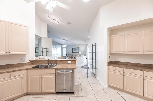 kitchen featuring dishwasher, light tile patterned floors, lofted ceiling, and sink