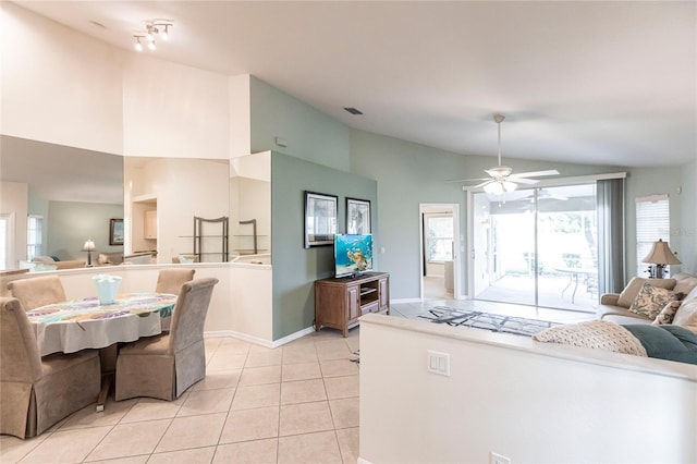 interior space with ceiling fan, light tile patterned floors, and vaulted ceiling