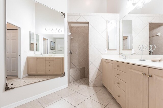 bathroom with tile patterned flooring, vanity, and tiled shower