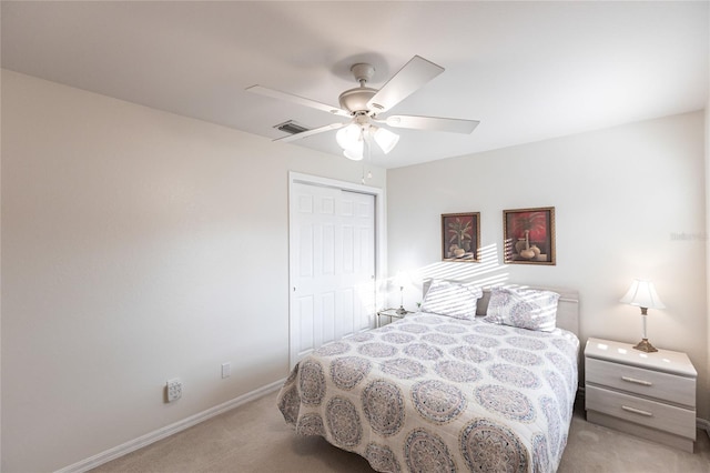 bedroom with ceiling fan, a closet, and light colored carpet