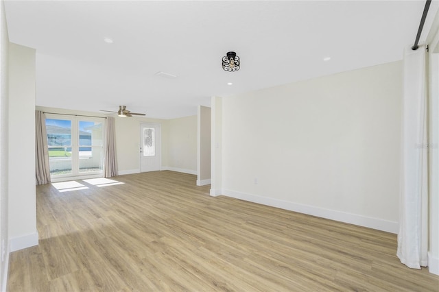 unfurnished living room featuring ceiling fan and light wood-type flooring