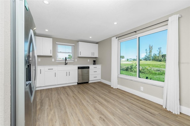 kitchen featuring white cabinets, light hardwood / wood-style floors, sink, and stainless steel appliances