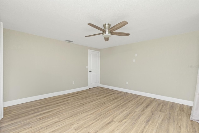 spare room with ceiling fan, a textured ceiling, and light wood-type flooring