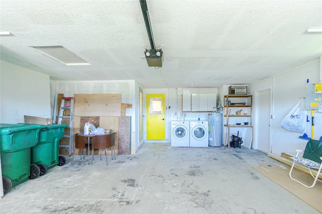 garage featuring washer and clothes dryer, a garage door opener, and water heater