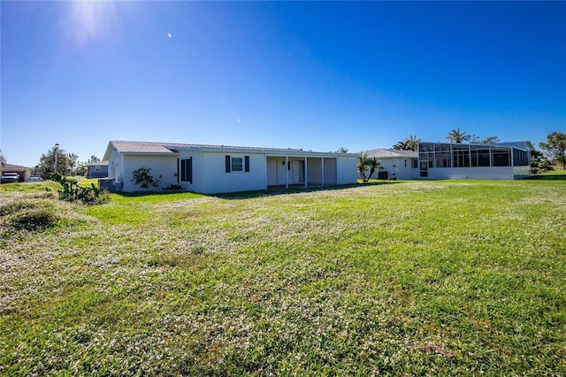 back of property featuring a sunroom and a yard