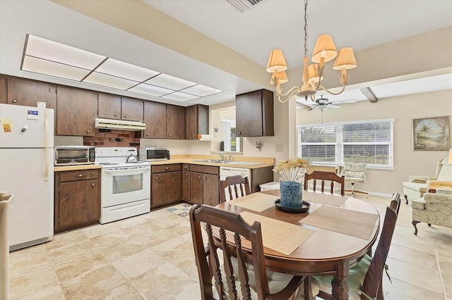 kitchen featuring dark brown cabinetry, sink, hanging light fixtures, an inviting chandelier, and white appliances