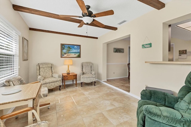 living area featuring beamed ceiling and ceiling fan