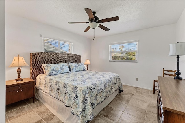 bedroom featuring ceiling fan and a textured ceiling