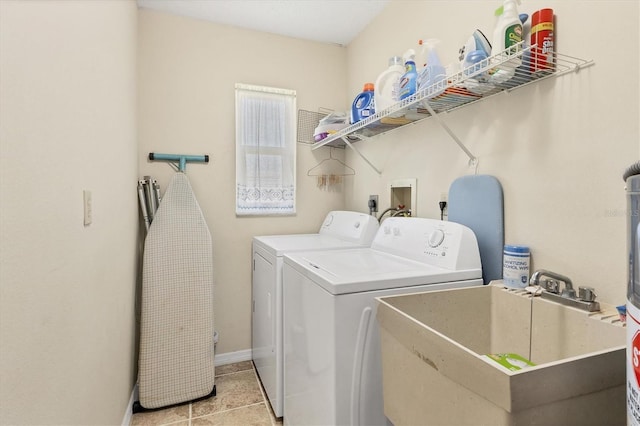 washroom featuring light tile patterned floors, sink, and washing machine and clothes dryer