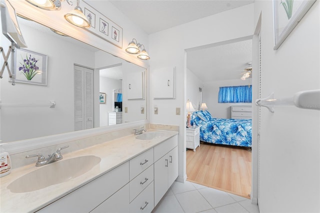 bathroom featuring a sink, double vanity, connected bathroom, and a closet