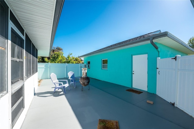 view of patio featuring a fire pit, a gate, and fence