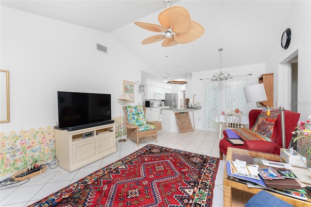 living area with ceiling fan with notable chandelier, vaulted ceiling, light tile patterned flooring, and visible vents