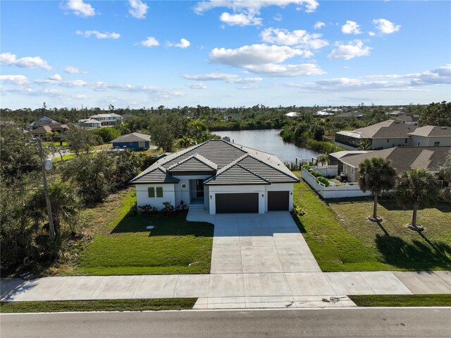 14681 Keystone Blvd, Port Charlotte, FL 33981 - view of front of home with an attached garage, driveway, a water view, a tiled roof, and stucco siding