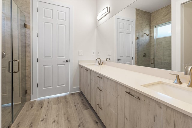 bathroom featuring hardwood / wood-style floors, vanity, and a shower with shower door