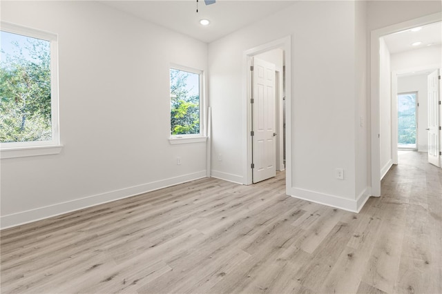 unfurnished room featuring ceiling fan, light hardwood / wood-style floors, and a wealth of natural light