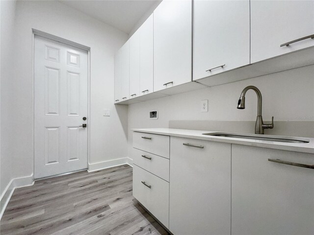 14681 Keystone Blvd, Port Charlotte, FL 33981 - washroom with cabinet space, light wood-style flooring, baseboards, and washer hookup