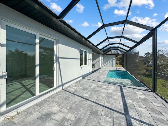 view of pool with glass enclosure and a patio