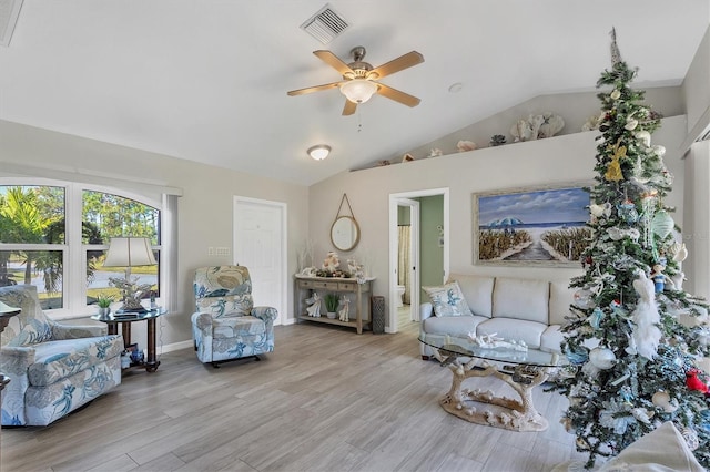 living room with ceiling fan, light hardwood / wood-style flooring, and lofted ceiling